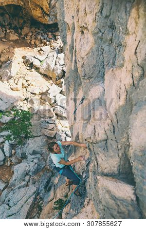 Rock Climbing And Mountaineering In The Paklenica National Park. A Woman Overcomes A Challenging Cli