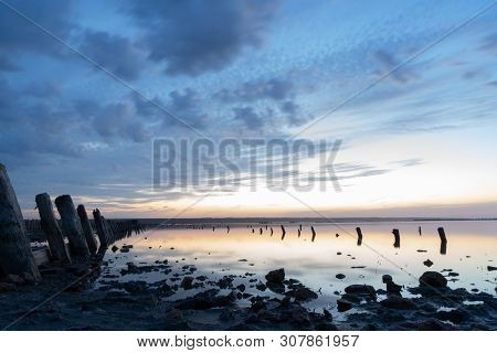 Sunset On The Kuyalnik Liman. Odessa. Ukraine. Old Logs Are Visible From The Water - The Remains Of 