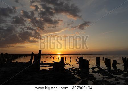 Sunset On The Kuyalnik Liman. Odessa. Ukraine. Old Logs Are Visible From The Water - The Remains Of 