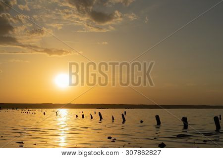Sunset On The Kuyalnik Liman. Odessa. Ukraine. Old Logs Are Visible From The Water - The Remains Of 