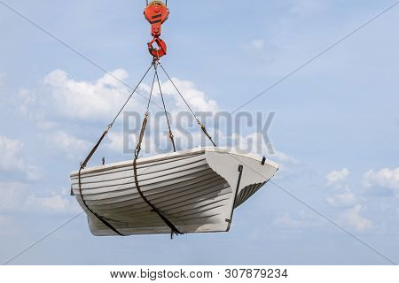 Rowing Wooden Boat Is Rising From The Sea By Using Crane