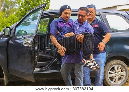 Labuan,malaysia-june 22,2019:people Assisting The Handicapped Man To Get Out Of A Car In Layang Laya
