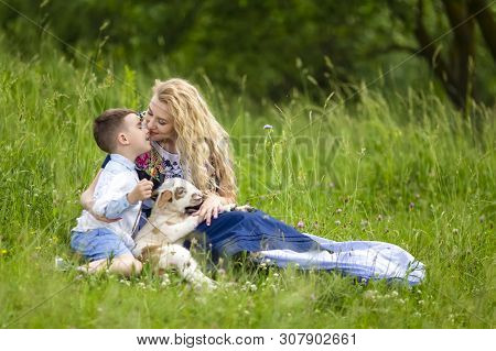Caucasian Mother With Her Little Son And Cub Of Newborn Lamb Posing Outdoors On Nature Background. H