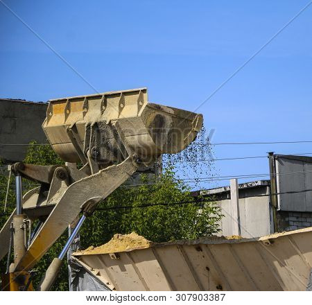 Tractor Collects Scoop With  Gravel. Excavator Extracts Sand And Gravel For  Concrete Mix.