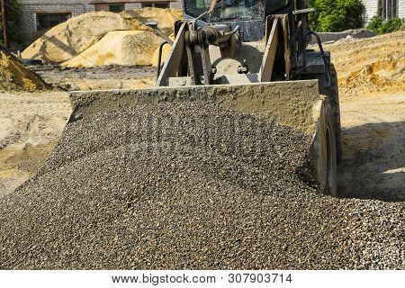 Tractor Collects Scoop With  Gravel. Excavator Extracts Sand And Gravel For  Concrete Mix.