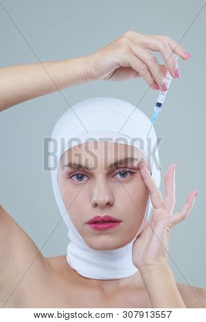 Young Woman In Head Bandage Making Herself Filler Injection To Get Rid Of Wrinkles