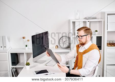 Mid Age Businessman Working With Dokuments At The Computer In Office
