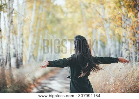 Dreamy Beautiful Girl With Long Natural Black Hair Flies On Bokeh Background Of Autumn Yellow Leaves