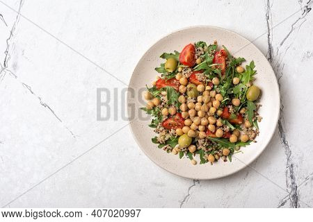 Healthy Vegetarian Salad With Cooked Chickpeas, Chia Seeds, Fresh Arugula, Cherry Tomatoes And Olive