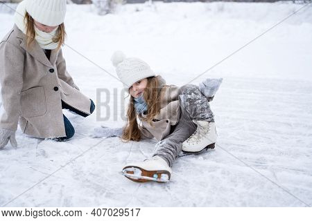 Beautiful Little Girls, Sisters Learn To Skate On Ice Skating Rink In Park. Fall And Have Fun. Styli