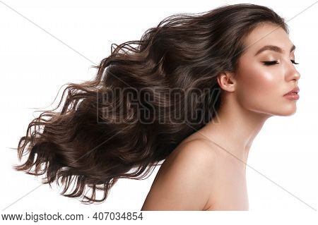 Beautiful Brown-haired Girl With A Perfectly Curls Hair, And Classic Make-up. Beauty Face And Hair.