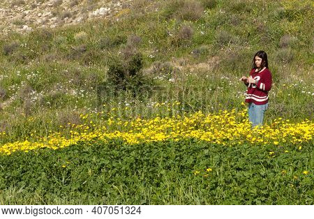 Happy Girl And A Field With Yellow Flowers In Spring. Spingtime Cyprus