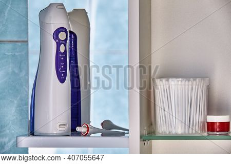 Electric Oral Irrigator Or Water Flosser In Bathroom Cabinet.