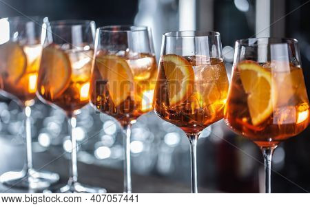 Typical Summer Sekt Drink Aperol Spritz Served In Wine Glasses With Aperol, Prosecco, Soda And A Sli