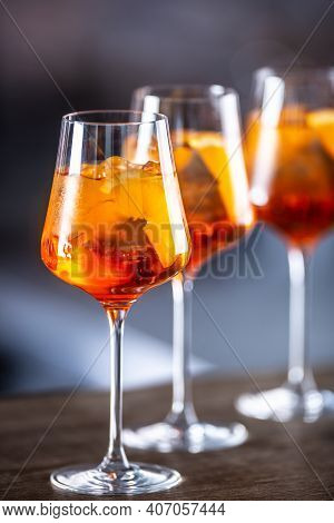 Typical Summer Sekt Drink Aperol Spritz Served In Wine Glasses With Aperol, Prosecco, Soda And A Sli