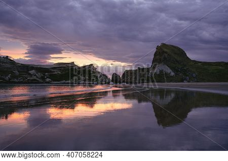 Sunset At The Beach With The Amazing View Of Castle Rock Reflected On The Water. New Zealand Landsca