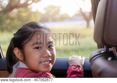 Asian Happy Student Smiling With Camera While Enjoying Road Trip In Car. Daughter Smiling And Lookin