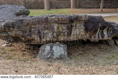 Dolmen Burial Chamber With Large Boulder Used As Capstone On Top Of Smaller Stones In Neolithic Park