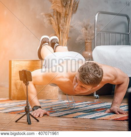 A Young Man Shoots A Video, A Sports Blog At Home. The Athlete Shows How To Do Push-ups Correctly, F