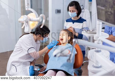 Angled Mirror Used By Dentist Doctor On Little Girl With Mouth Open In Dental Office. Dentistry Spec