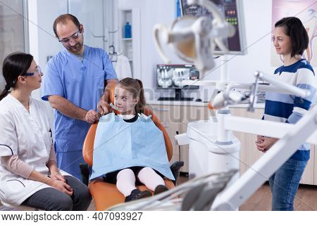 Dental Specialist Talking With Parent About Kid Mouth Hygine For Health In Dentist Office. Child Wit