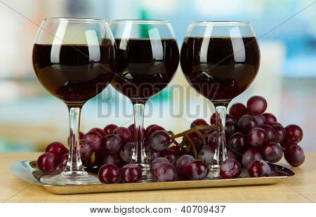 Vino rosso in vetro su salver sullo sfondo della camera