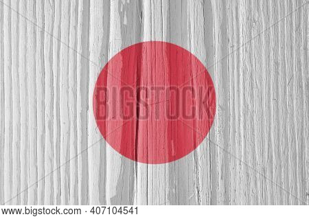 The Flag Of Japan On A Dry Wooden Surface, Cracked With Age. Light Pale Faded Paint. Patriotic Backg