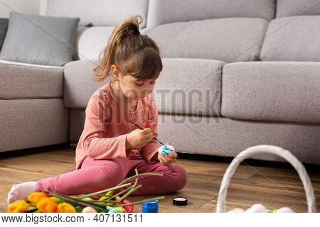 Baby Gorl Painting Easter Eggs At Home. Copy Space