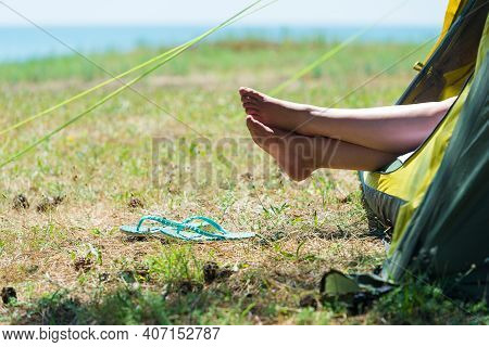 Woman Resting In A Tent By The Sea, In The Frame Of The Legs