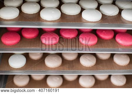 French Dessert Macarons Cookies. Close Up Horizontal Shot Of Colorful White, Red And Caramel Macaron