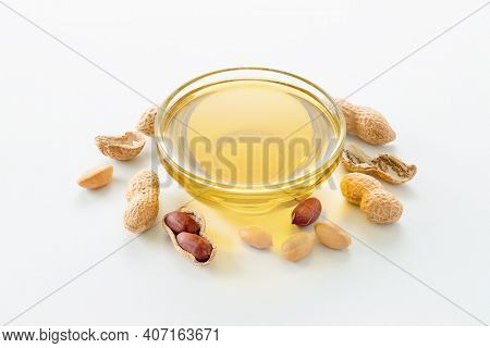 Natural peanut oil in a bowl with peanuts