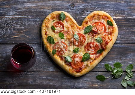 Homemade Delicious Margarita Pizza With Tomatoes And Basil In The Shape Of A Heart With A Glass Of R