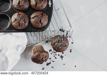 Homemade Chocolate Muffins Or Muffins, Garnished With Chocolate Chips, On A Light Table, Overlooking