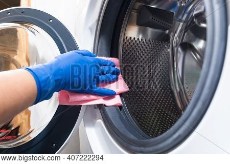 Hand In Blue Glovesw Cleaning Washing Mashine With Piece Of Cloth