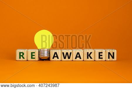 Reawaken Symbol. Wooden Cubes With Word 'reawaken'. Yellow Light Bulb. Beautiful Orange Background. 