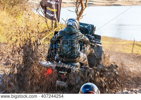 Afipsip, Russia - October 31, 2020: Sportsman On Quad Bike Drives Splashing In Water At Mud Racing C
