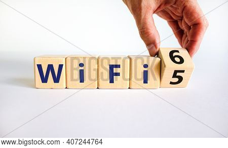 Wifi 5 Or 6 Symbol. Businessman Turns A Wooden Cube And Changes The Words Wifi 5 To Wifi 6. Beautifu