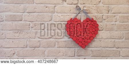 Red Heart Hanging On Brick Wall. Textured Symbol Of Love. Two Handmade Hearts On Light Brick Wall. C