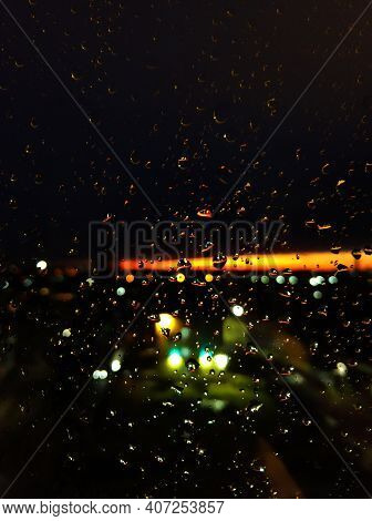 Raindrops On Glass. Livin During Sunset. Night Sky With A Bright Orange Stripe.