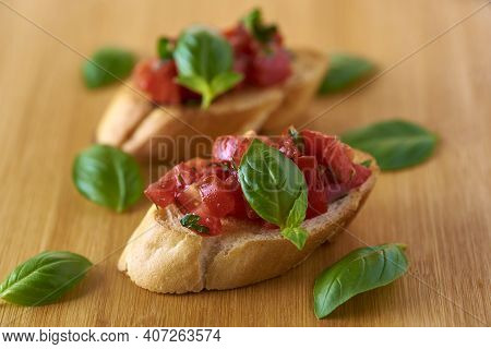 Bruschetta With Tomatoes And Basil On A Wooden Stand
