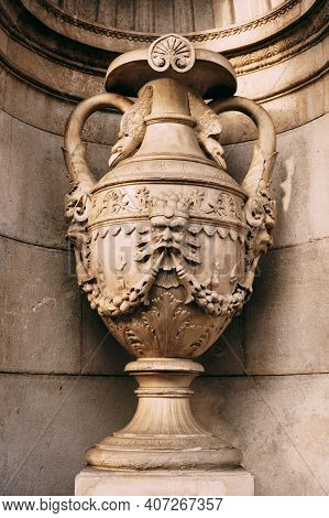 Antique Flowerpot In An Old Hall With Patterns And A Bas-relief Image.