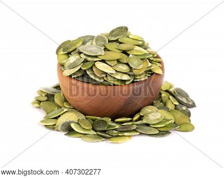 Pumpkin Seeds In Wooden Bowl, Isolated On White Background. Green Pepita Seeds.