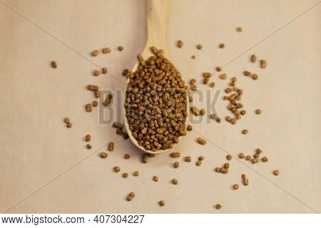 Buckwheat Tea In A Wooden Spoon On A Brown Background. Buckwheat Tea Close-up Macro Photography. Sca