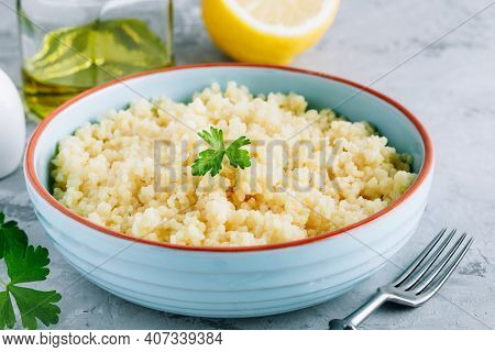 Cooked Couscous In Blue Ceramic Bowl On The Table. Selective Focus, Copy Space.