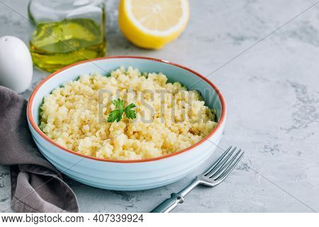 Cooked Couscous In Blue Ceramic Bowl On The Table, Copy Space.