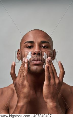 Person Pressing White Anti-wrinkle Strips Tighter To Skin On Both Sides Of His Face