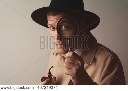 Male Detective With Smoking Pipe Looking Through Magnifying Glass On Beige Background