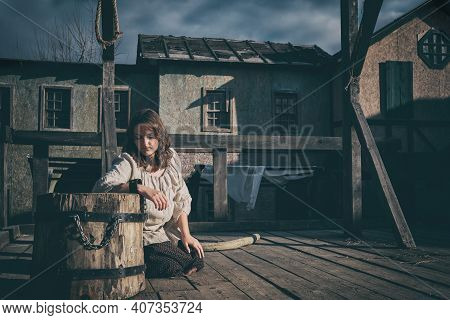 Woman Prisoner Chained To The Shackles Near The Gallows. Execution Of A Woman Against The Background