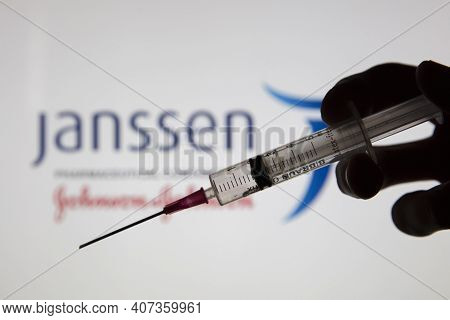 Oxford, Uk - February 2020: A Covid Vaccine Syringe Against The Janssen Logo