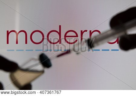 Oxford, Uk - February 2020: A Covid Vaccine Needle Against The Moderna Logo